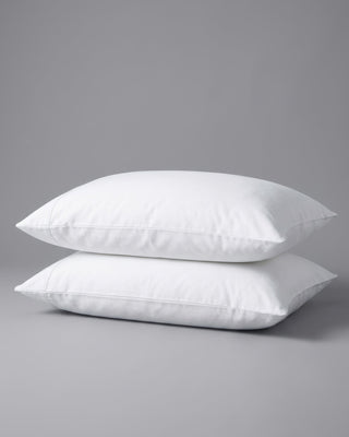 Two white pillows stacked on a gray background