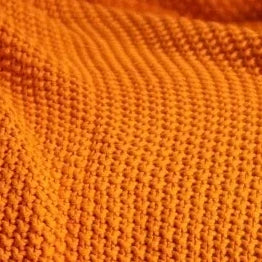 Close view of Hallen's burnt orange cotton knit